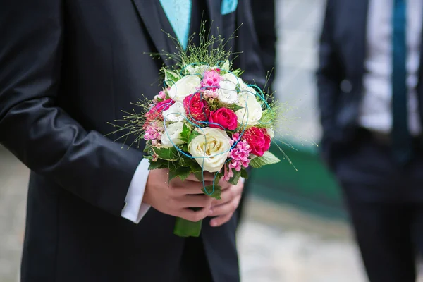 Жених держит свадебный букет своей невесты — стоковое фото