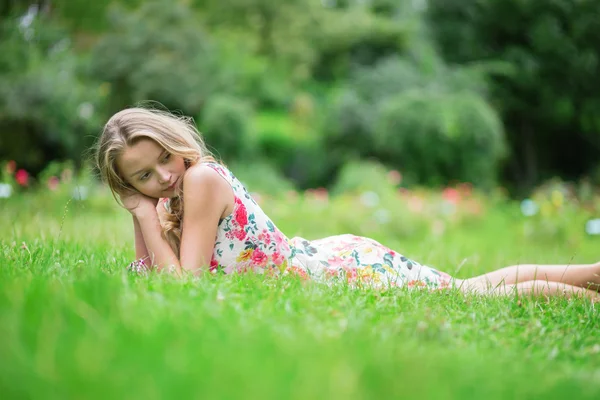 Giovane ragazza sdraiata sull'erba in un giorno d'estate — Foto Stock