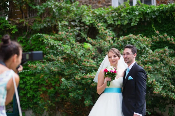 Bruden och brudgummen poserar till photogtrapher — Stockfoto