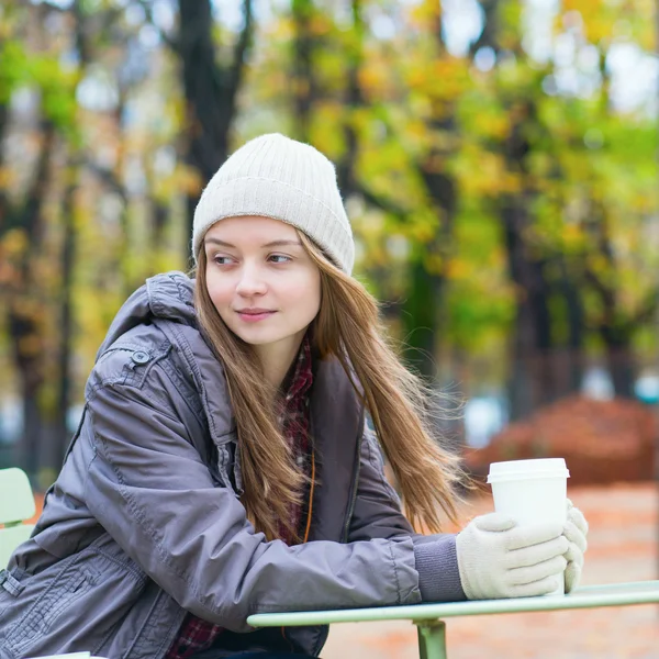 Young Parisian girl drinking coffee in park — Stock Photo, Image