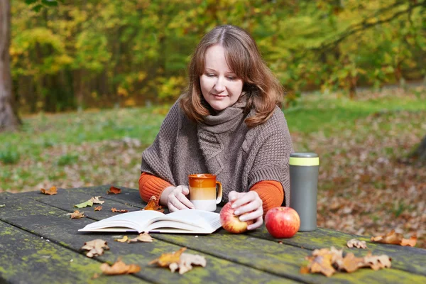 Meisje het lezen van een boek in park — Stockfoto