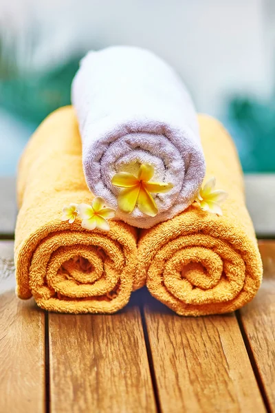 Towels with white frangipani flowers in spa — Stock Photo, Image