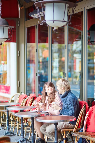 Счастливая молодая пара пьет кофе в кафе — стоковое фото