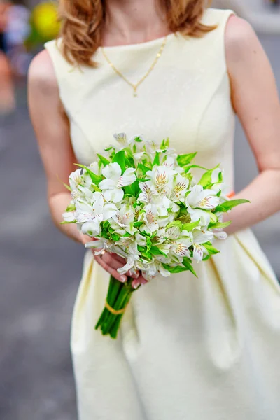 Giovane sposa che tiene tra le mani fiori di nozze — Foto Stock