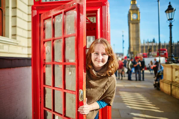 Happy turista koukal z červené phonebox — Stock fotografie