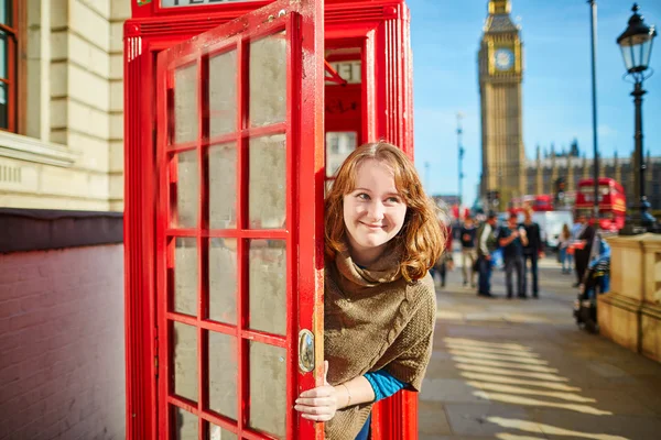 Glücklicher Tourist schaut aus der roten Telefonzelle — Stockfoto