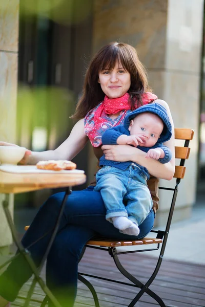 Beautiful young mother with her baby in cafe — Stock Photo, Image