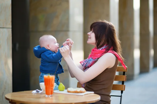 Beautiful young mother with her baby in cafe — Stock Photo, Image