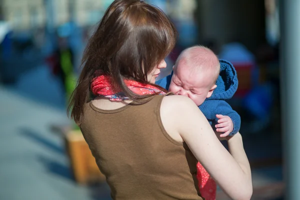 Lilla bebis gråter i sin mors armar — Stockfoto