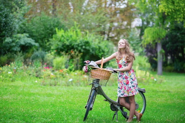 Felice ragazza con bicicletta e fiori — Foto Stock