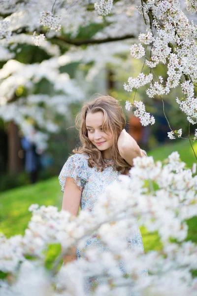 Beautiful girl in cherry blossom garden — Stock Photo, Image