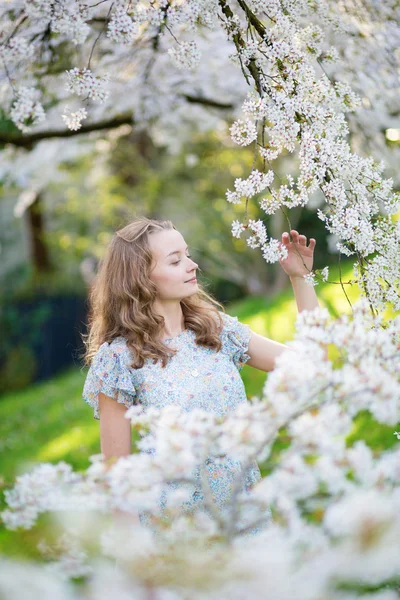 Beautiful girl in cherry blossom garden — Stock Photo, Image