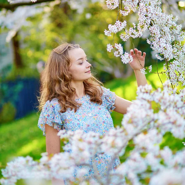 Young woman in cherry blossom garden — Stock Photo, Image