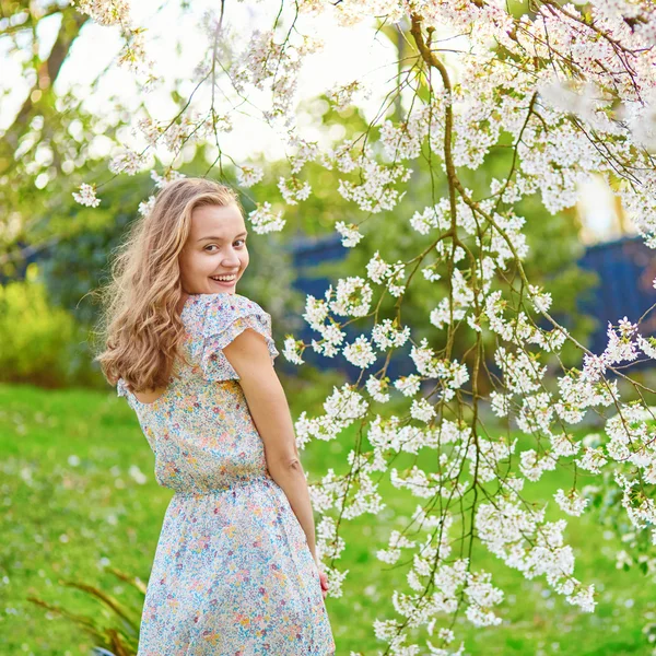 Young woman in cherry blossom garden — Stock Photo, Image