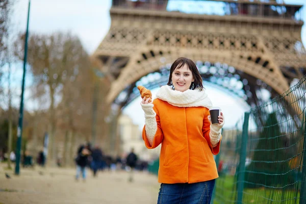 Mladá žena v Paříži s kávou a croissantem — Stock fotografie