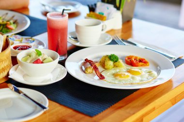 Kızarmış yumurta, meyve salatası ve taze meyve suyu