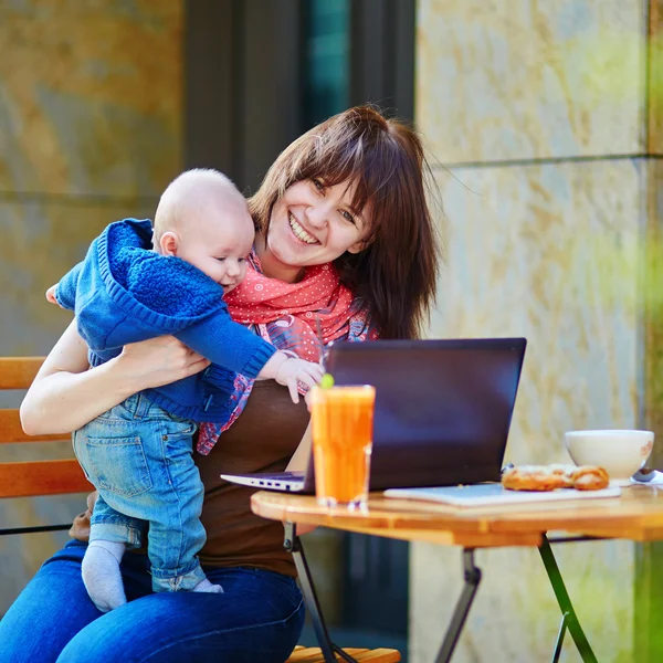 Young working mother with her son in a cafe — Stock Photo, Image