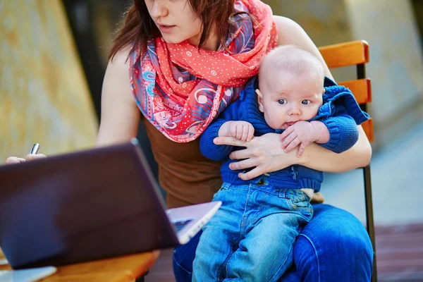 Jeune mère qui travaille avec son fils dans un café — Photo