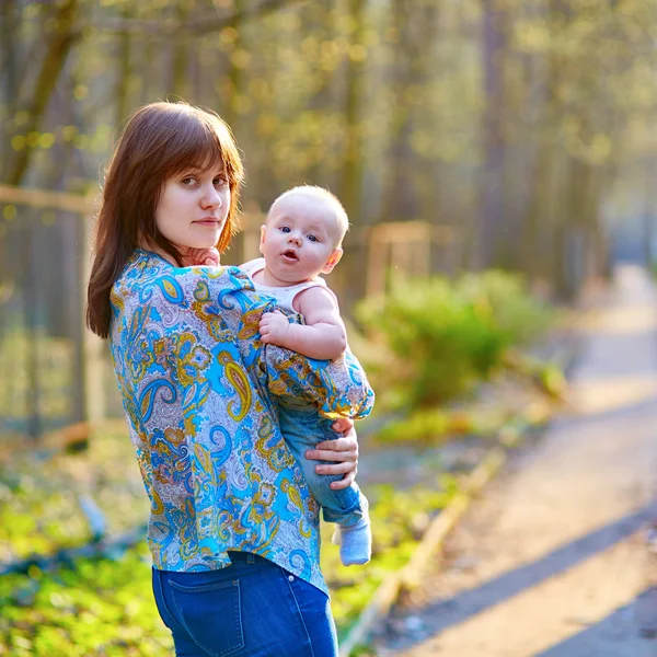 Jovem mãe com seu filhinho em um dia de primavera — Fotografia de Stock
