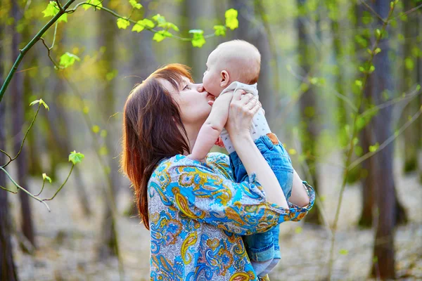 Joven madre con su pequeño hijo en un día de primavera — Foto de Stock