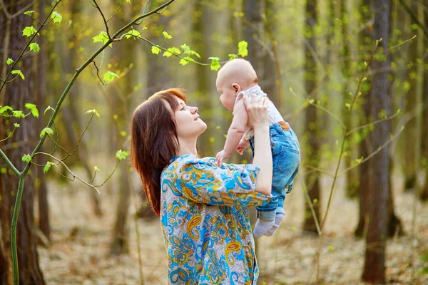 Giovane madre con il suo piccolo figlio in un giorno di primavera — Foto Stock