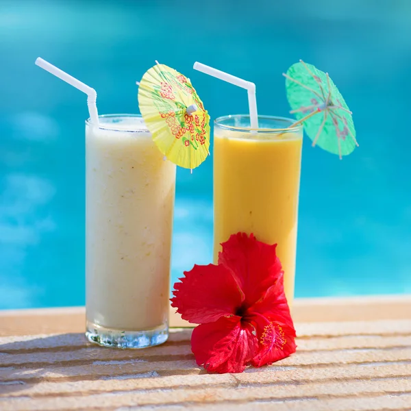 Zwei frische Fruchtcocktails auf Holzplanken vor einem blauen sw — Stockfoto