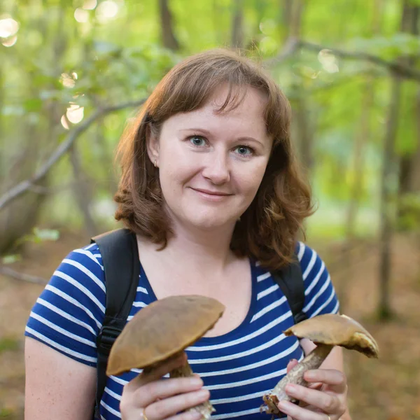 Счастливая девушка с грибами в лесу — стоковое фото