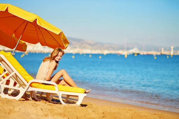 Meisje ontspannen op een strandstoel in de buurt van de zee — Stockfoto