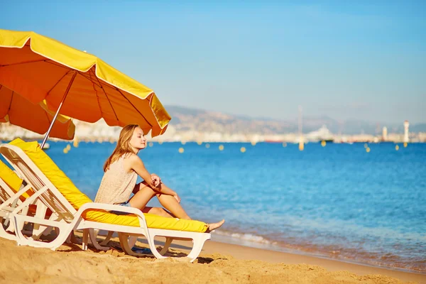 Девушка отдыхает на пляжном стуле у моря — стоковое фото