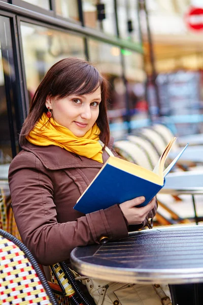 Young woman with a book in cafe — Stock Photo, Image