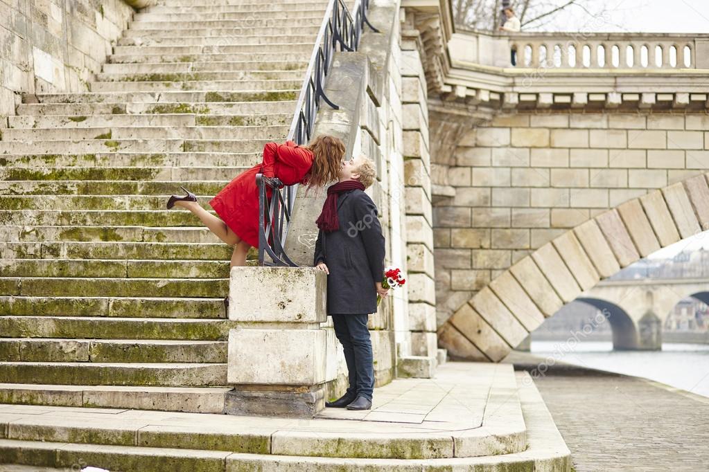 Couple kissing on a Parisian embankment
