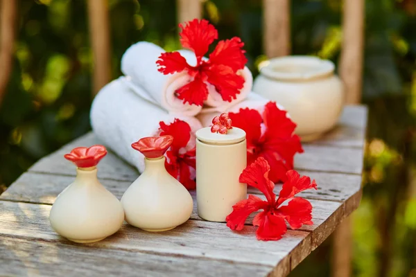 Spa setting with towels and red flowers — Stock Photo, Image