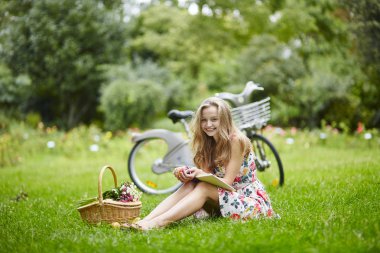 Eading açık havada bir kitap ile genç kız