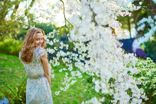 Beautiful girl in cherry blossom garden — Stock Photo, Image