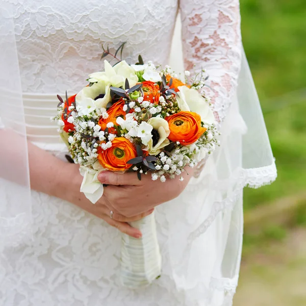 年轻的新娘抱着美丽的婚礼花束 — 图库照片