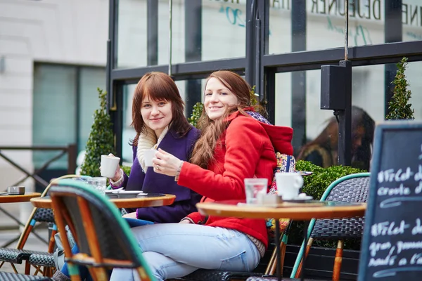 Två glada unga flickor i en parisisk gata café — Stockfoto