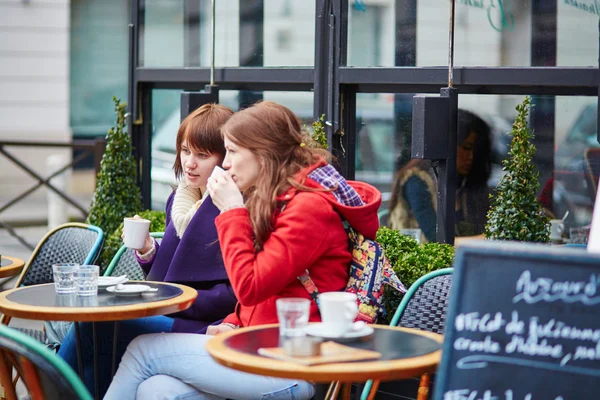 Two cheerful young girls in a Parisian street cafe — Stock Photo, Image