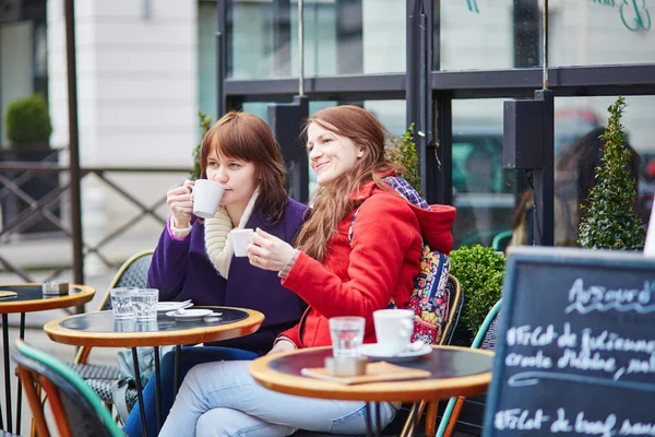 Två glada unga flickor i en parisisk gata café — Stockfoto