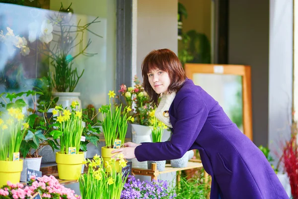 Flickan välja blommor i en parisisk blomsteraffär — Stockfoto