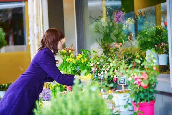 Flickan välja blommor i en parisisk blomsteraffär — Stockfoto