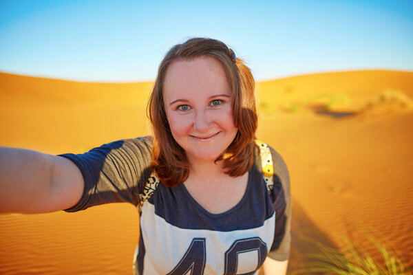 Happy tourist taking selfie in Sahara