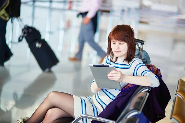 Passageiro jovem no aeroporto, usando seu tablet — Fotografia de Stock