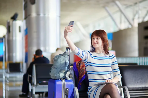 Young passenger at the airport, making selfie — Stok fotoğraf