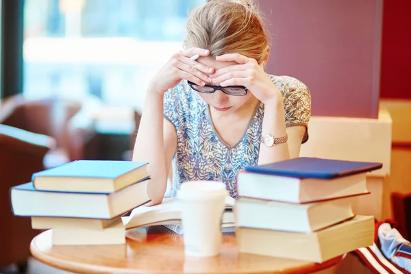 Beautiful young student with lots of books