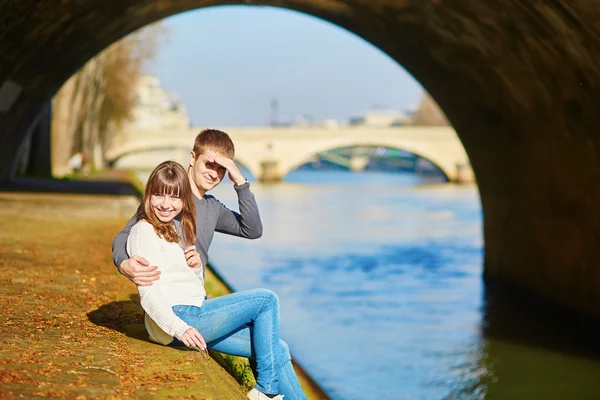 Beautiful couple in Paris walking by the Seine — Stock Photo, Image