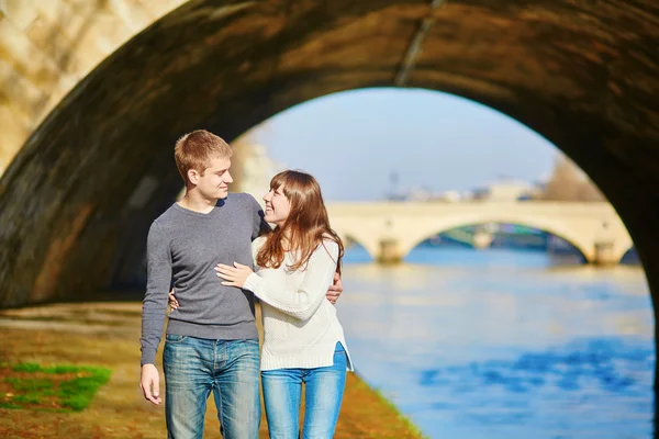 Beautiful couple in Paris walking by the Seine — Stock Photo, Image