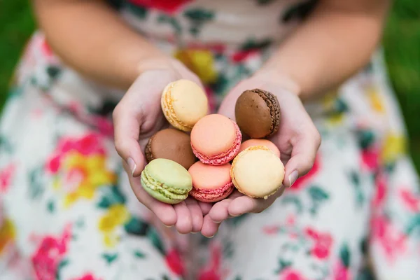 Girl holding French macaroons in hands — Stock Photo, Image