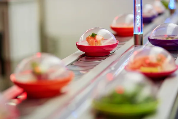 Assiettes de sushi sur rails au restaurant japonais — Photo