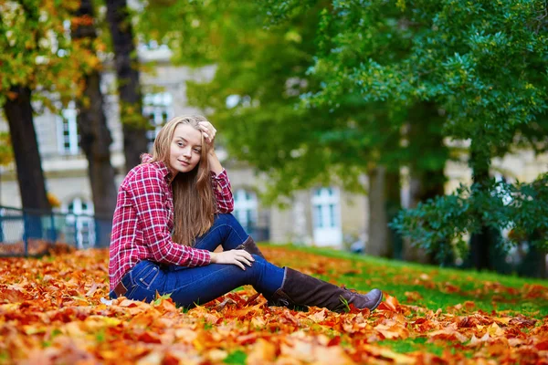 Zamyšlená dívka sedící na zemi na podzim — Stock fotografie