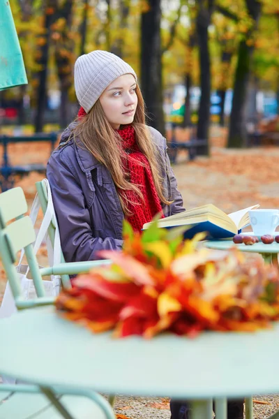 Ragazza che legge un libro in un caffè all'aperto — Foto Stock